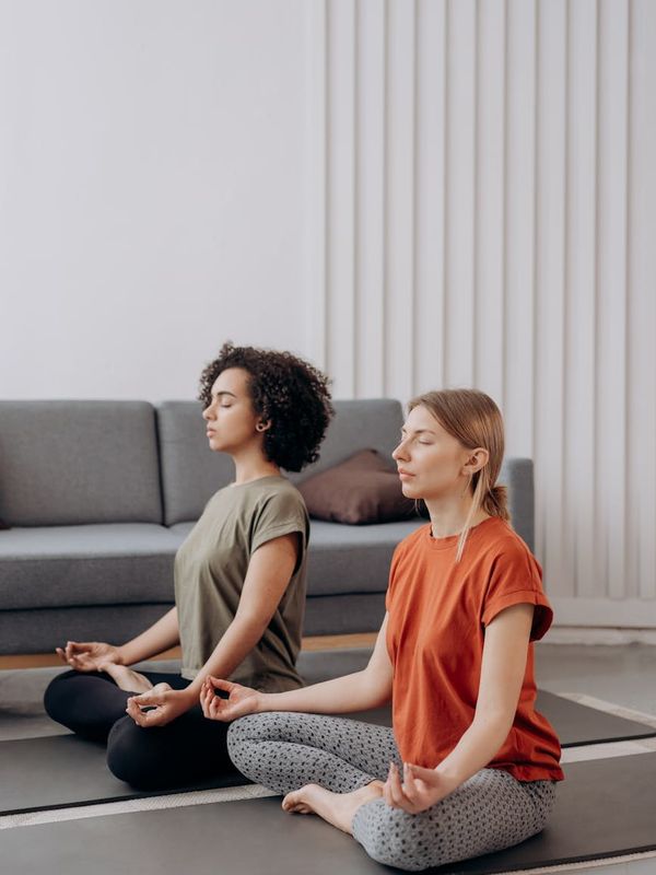 Woman in a calm yoga pose in a softly lit room.